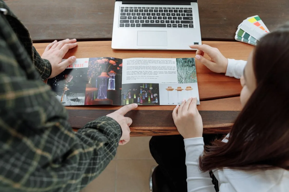 Profesionales revisando un brochure y material comercial impreso sobre una mesa de trabajo