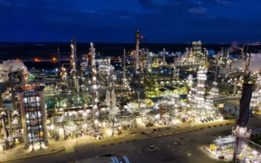 Complejo industrial energético iluminado al anochecer visto desde el aire, la clase de faena que una agencia B2B industrial debe saber describir sin equivocarse