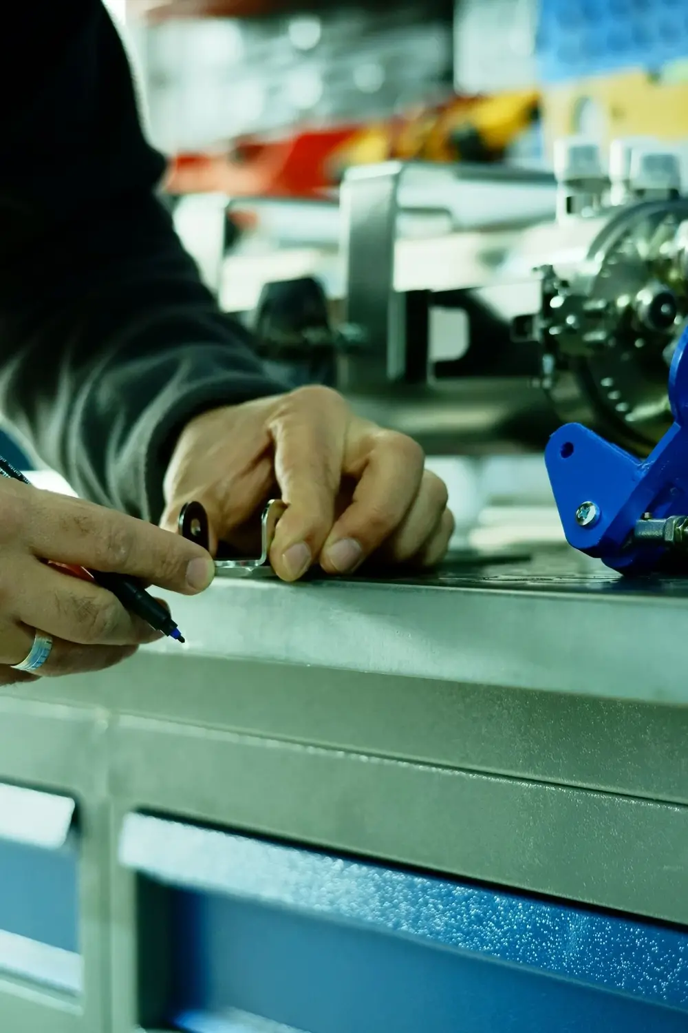Manos midiendo y marcando una pieza metálica con precisión en taller